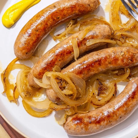 Saftig gebratene Bratwürste, perfekt gebräunt und serviert mit knusprigen Zwiebeln.